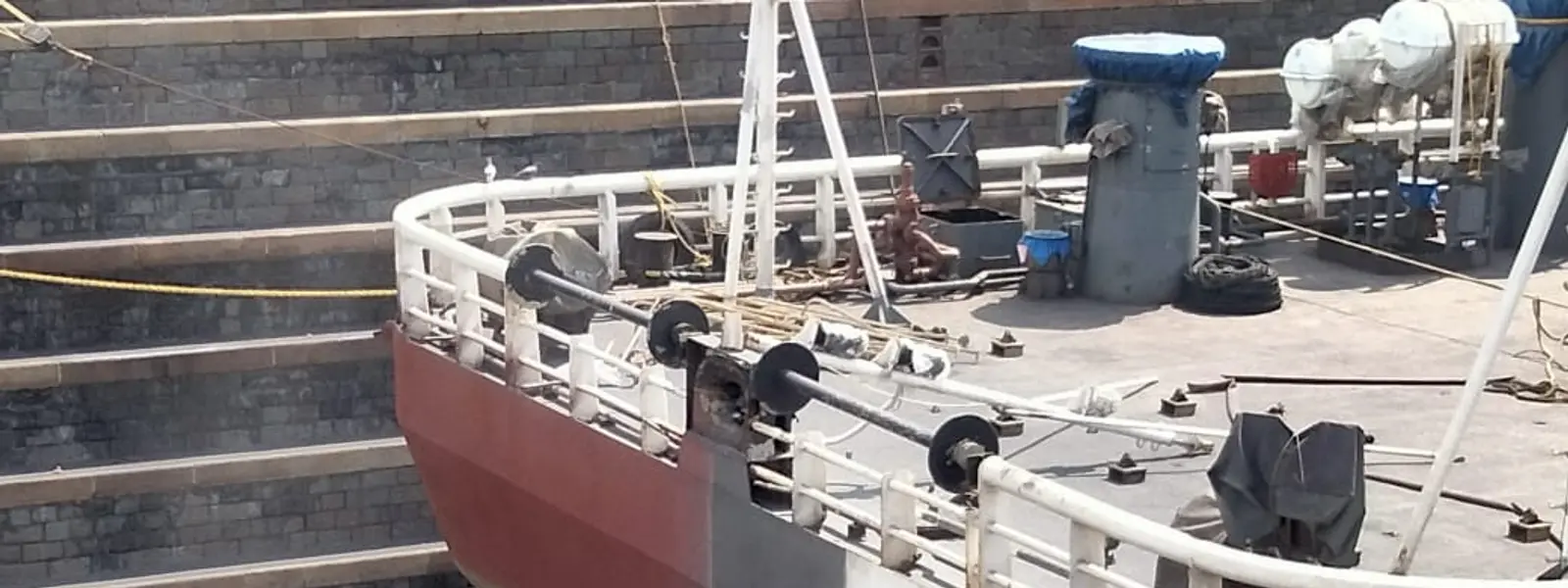 Marine technician grit blasting a vessel hull