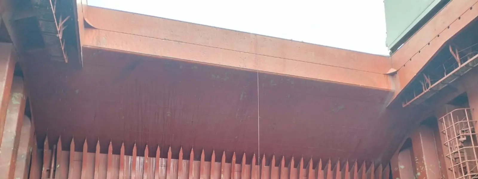 Workers cleaning a large cargo hold