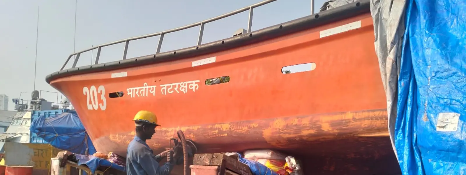 Technician applying fiber repair to an FRP boat
